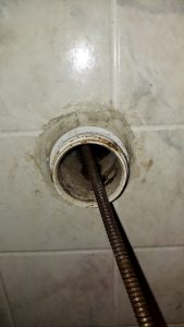 professional drain auger clearing a clogged drain line during drain cleaning service